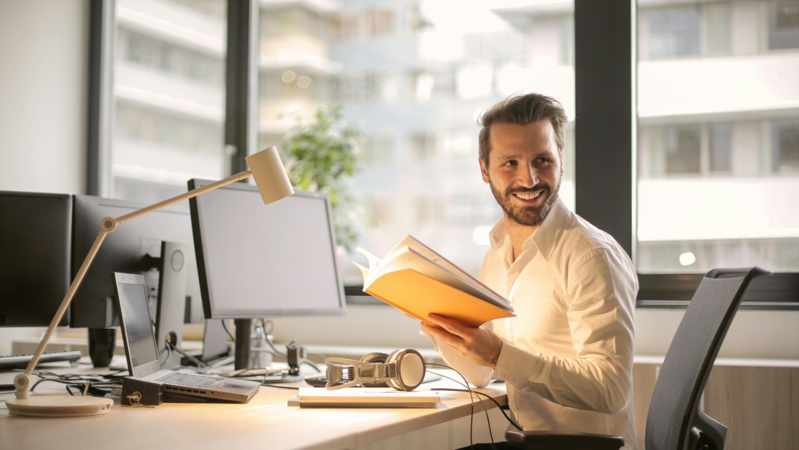 A relaxed businessman enjoying a break in his bright, contemporary office environment.